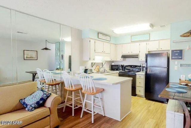 kitchen featuring kitchen peninsula, white cabinetry, electric range, light wood-type flooring, and black fridge