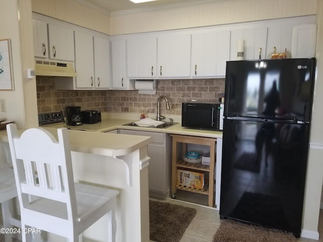 kitchen with white cabinetry, exhaust hood, black appliances, dark tile patterned floors, and sink