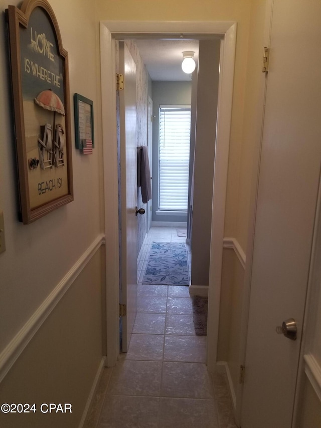 hallway with dark tile patterned flooring