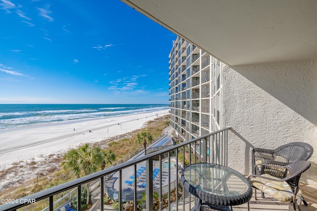 balcony featuring a water view and a view of the beach