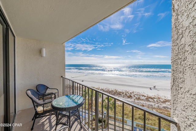 balcony with a water view and a beach view