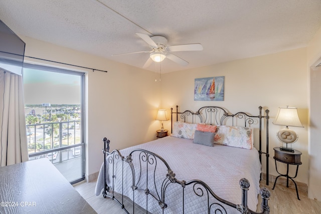 bedroom featuring ceiling fan, access to exterior, and a textured ceiling