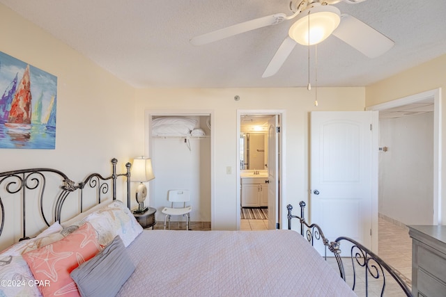 bedroom with ceiling fan, ensuite bath, and a textured ceiling