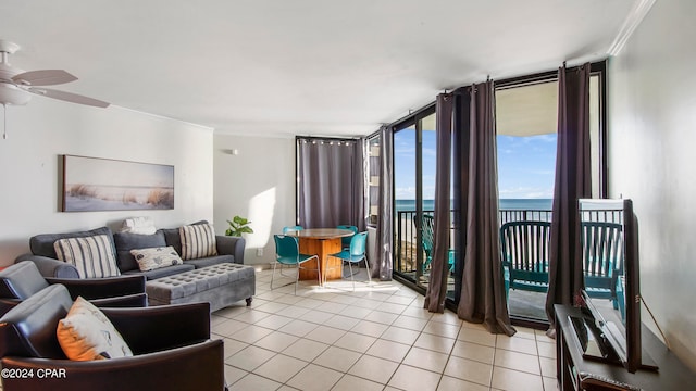 living room with a wall of windows, ceiling fan, light tile floors, ornamental molding, and a water view