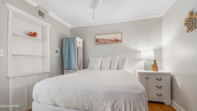 bedroom with ornamental molding and light wood-type flooring