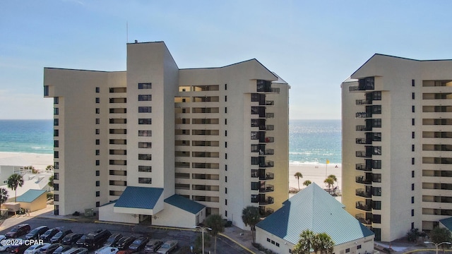 view of building exterior with a water view and a view of the beach