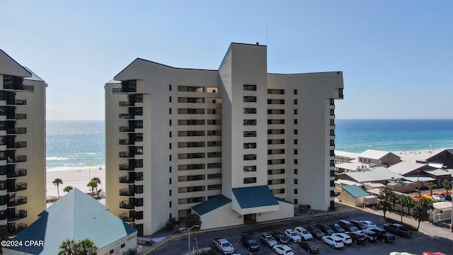 view of building exterior featuring a beach view and a water view