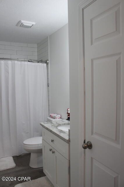 bathroom featuring hardwood / wood-style flooring, toilet, and vanity