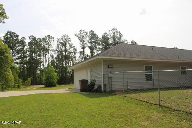 view of home's exterior featuring a lawn and a garage