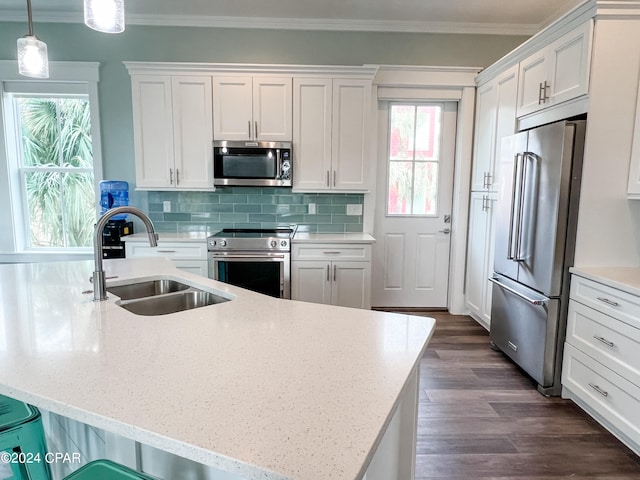 kitchen with decorative light fixtures, backsplash, dark wood-type flooring, premium appliances, and sink