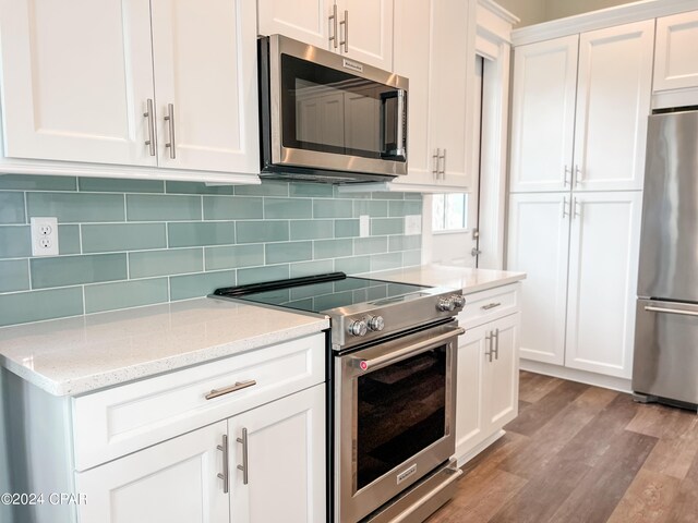 kitchen with a healthy amount of sunlight, sink, light stone countertops, and white cabinetry