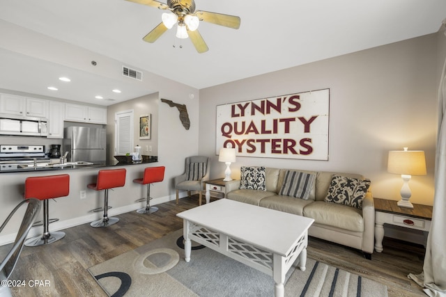 living room featuring dark hardwood / wood-style floors and ceiling fan