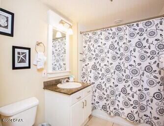 bathroom featuring tile flooring, oversized vanity, and toilet