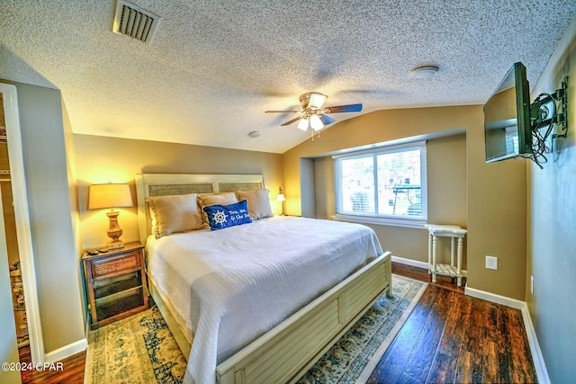 bedroom with dark hardwood / wood-style flooring, a textured ceiling, ceiling fan, and lofted ceiling