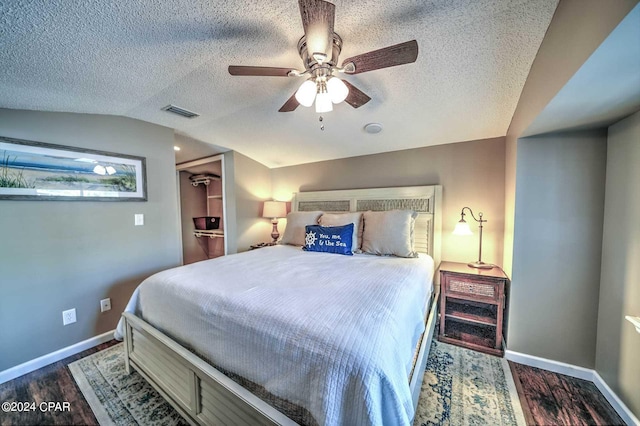 bedroom featuring lofted ceiling, a textured ceiling, ceiling fan, and dark hardwood / wood-style floors