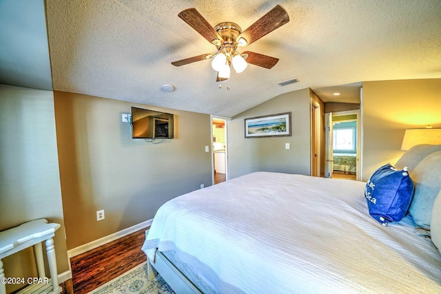 bedroom with vaulted ceiling, a textured ceiling, ceiling fan, and dark hardwood / wood-style flooring