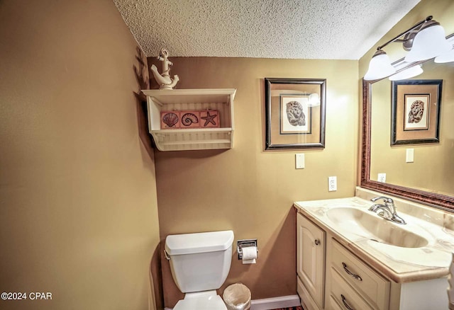 bathroom with oversized vanity, toilet, and a textured ceiling