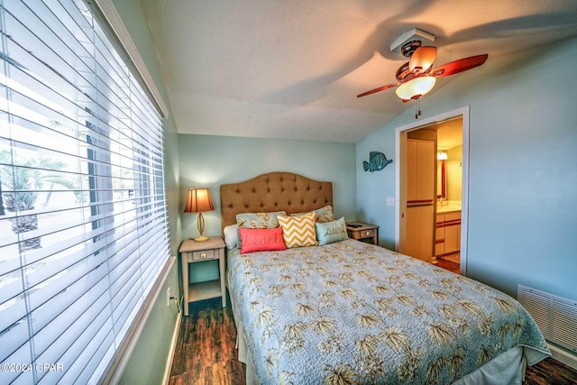 bedroom featuring ensuite bathroom, dark hardwood / wood-style flooring, ceiling fan, and lofted ceiling