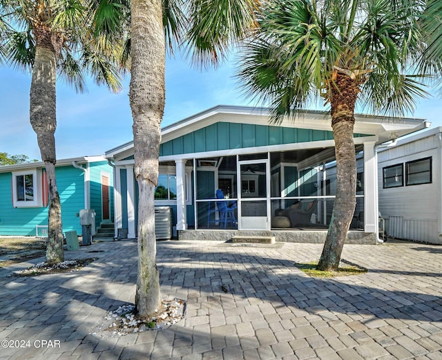 view of front facade featuring a sunroom and central air condition unit