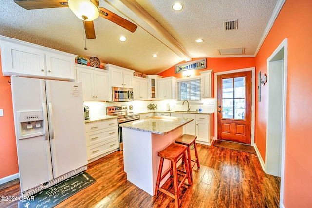 kitchen with ceiling fan, sink, a kitchen island, stainless steel appliances, and dark wood-type flooring