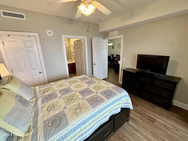 bedroom with dark hardwood / wood-style flooring, ceiling fan, and ensuite bath