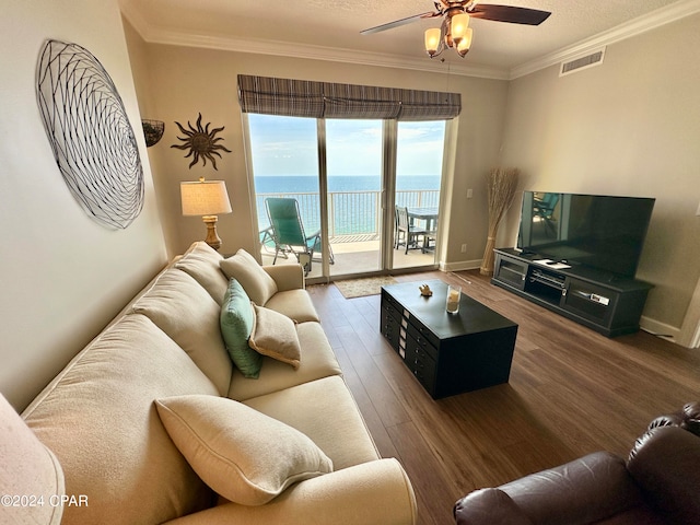 living room featuring ornamental molding, dark hardwood / wood-style flooring, ceiling fan, and a water view