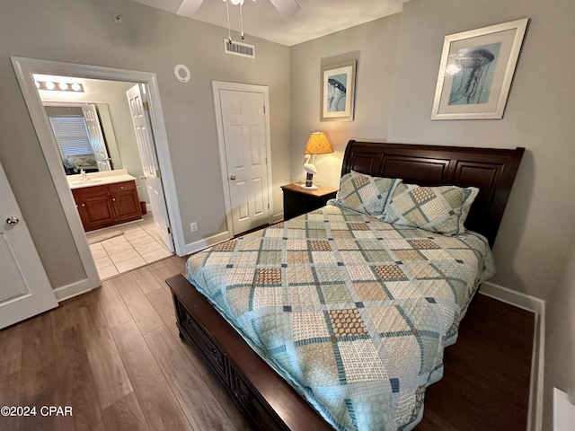 bedroom featuring ensuite bath, light hardwood / wood-style floors, ceiling fan, and sink