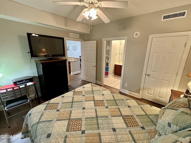 bedroom featuring ceiling fan, dark wood-type flooring, and connected bathroom