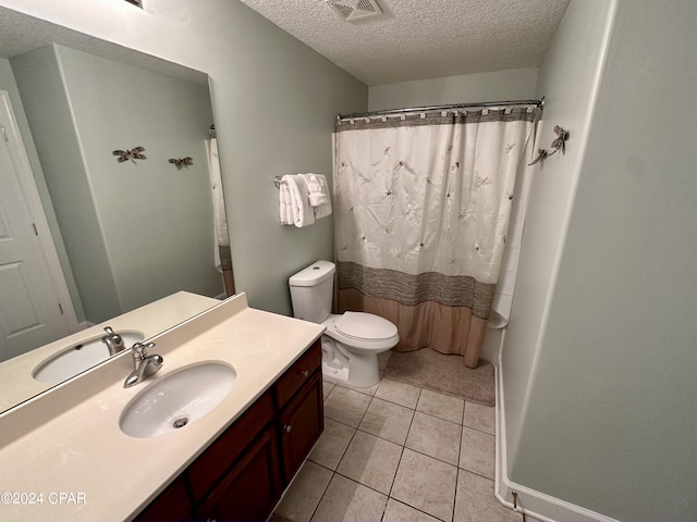 bathroom featuring a textured ceiling, vanity, tile floors, and toilet