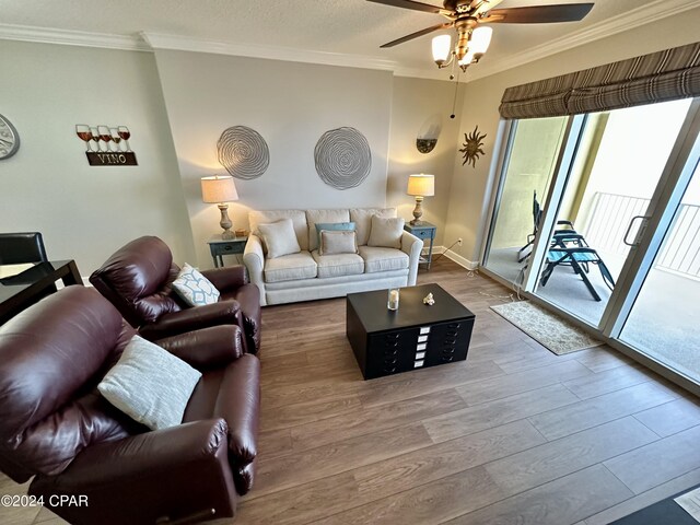 living room featuring ornamental molding, a healthy amount of sunlight, and light wood-type flooring