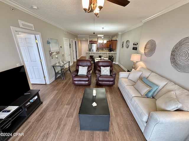 living room featuring a textured ceiling, hardwood / wood-style floors, ceiling fan, and ornamental molding