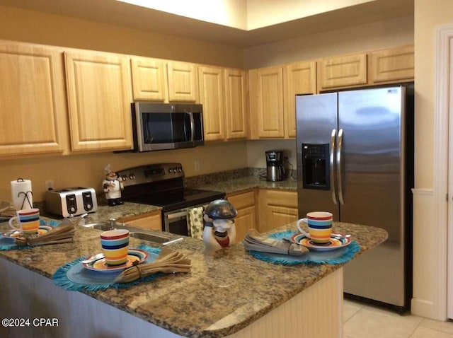 kitchen featuring appliances with stainless steel finishes, light tile flooring, kitchen peninsula, and light brown cabinets