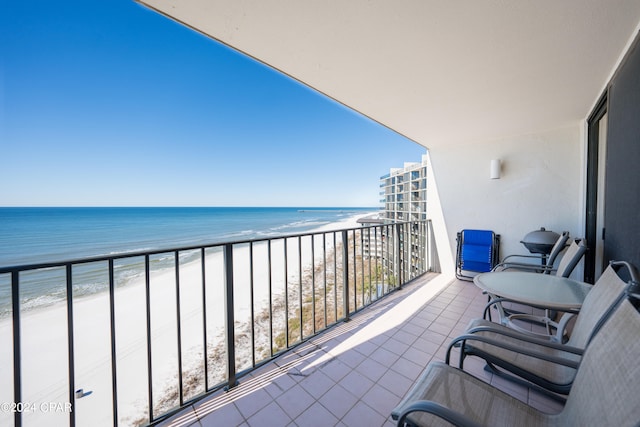 balcony with a water view and a view of the beach