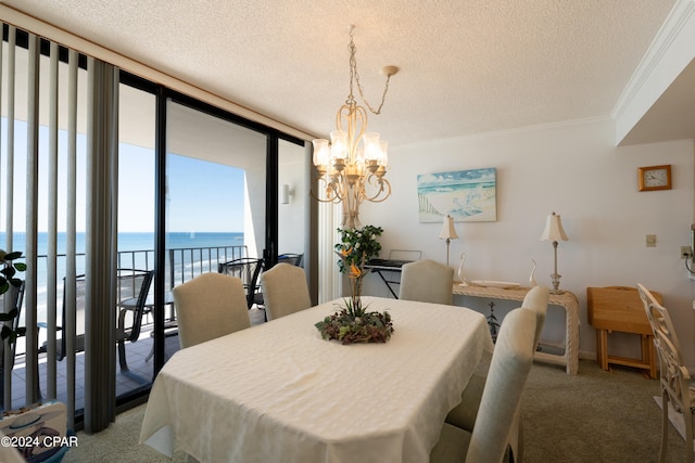 carpeted dining room featuring an inviting chandelier, a water view, a textured ceiling, floor to ceiling windows, and crown molding