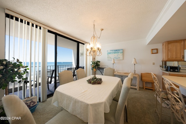 carpeted dining area with an inviting chandelier, a water view, a textured ceiling, floor to ceiling windows, and crown molding