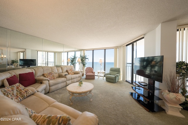 carpeted living room featuring a water view, a healthy amount of sunlight, a textured ceiling, and a wall of windows