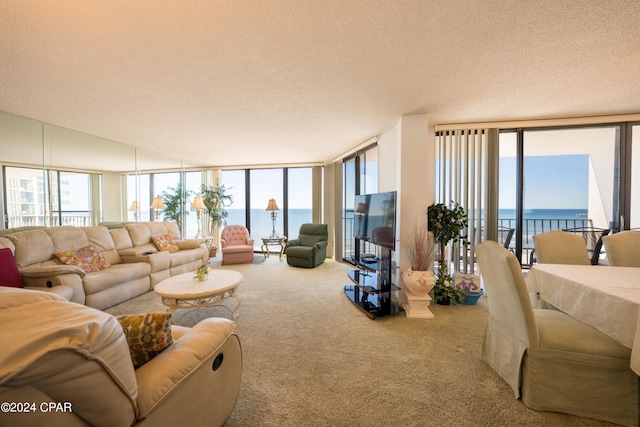 carpeted living room featuring a textured ceiling, expansive windows, and a water view