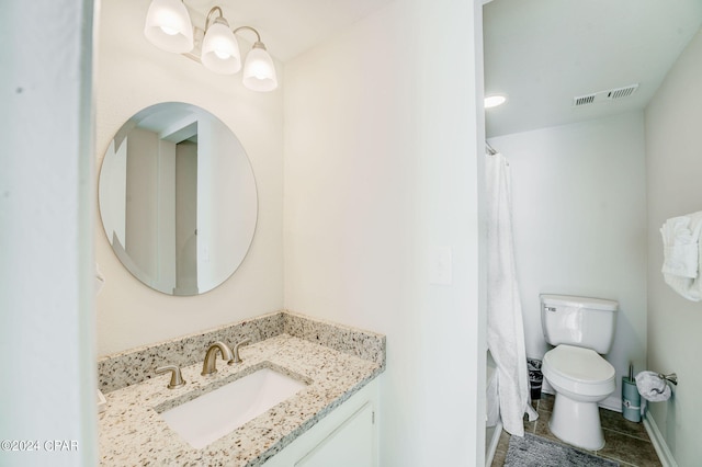 bathroom with toilet, vanity, and tile flooring