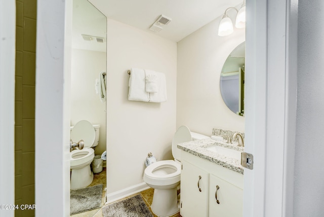 bathroom featuring tile flooring, toilet, and vanity