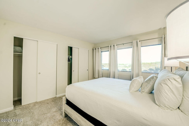 carpeted bedroom featuring multiple closets