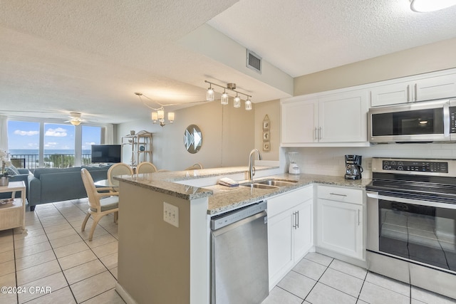 kitchen featuring a textured ceiling, white cabinetry, appliances with stainless steel finishes, and track lighting