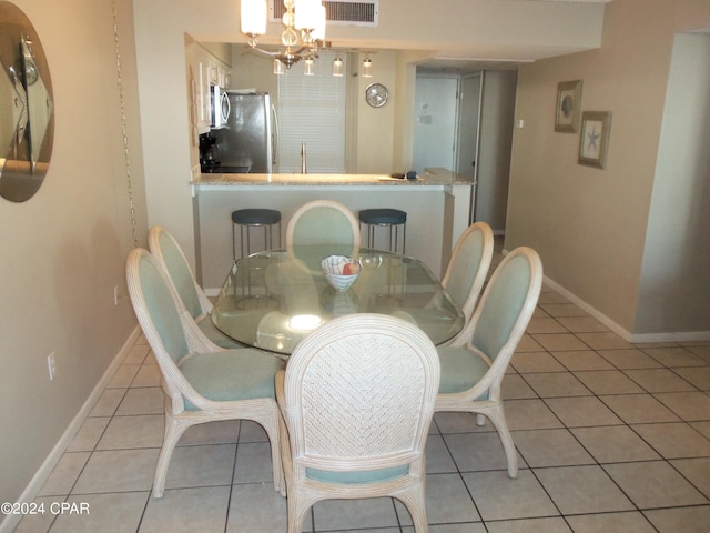 dining room featuring a chandelier and light tile floors