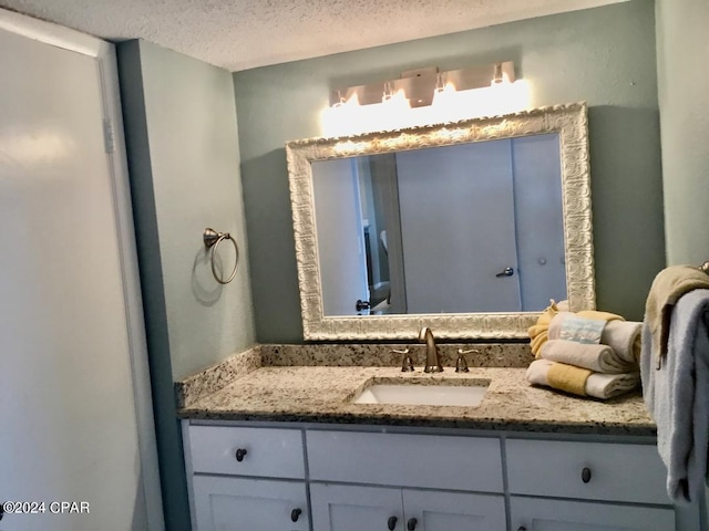 bathroom with a textured ceiling and vanity