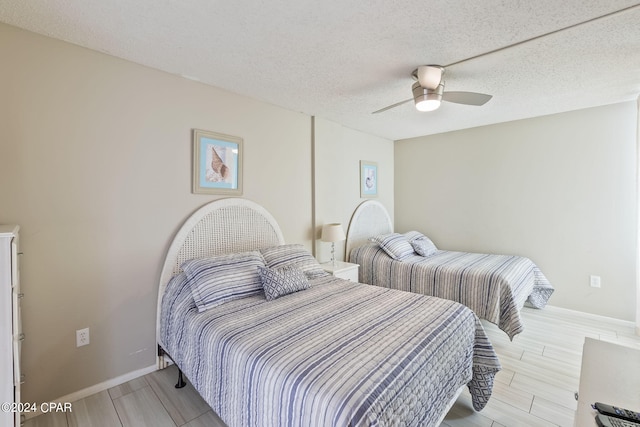 bedroom with ceiling fan and a textured ceiling