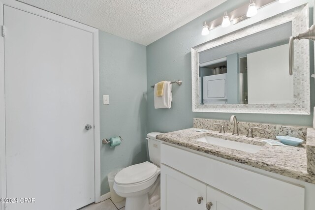 bathroom featuring oversized vanity, toilet, a textured ceiling, and tile flooring