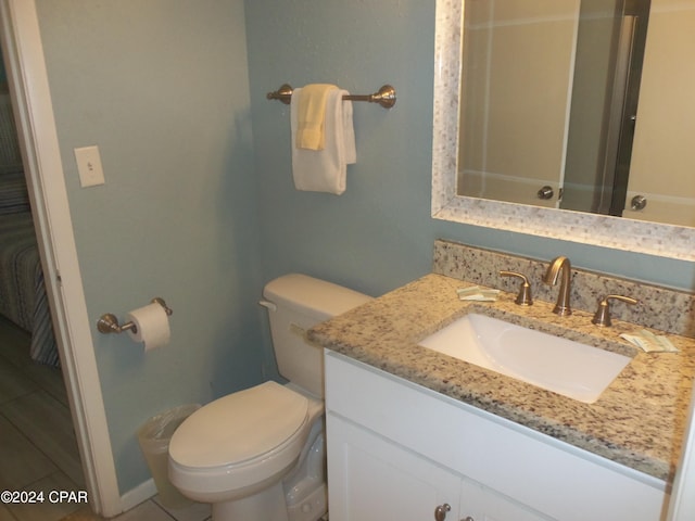 bathroom with tile floors, toilet, and vanity