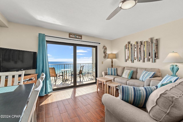 living room with a water view, ceiling fan, and dark wood-type flooring