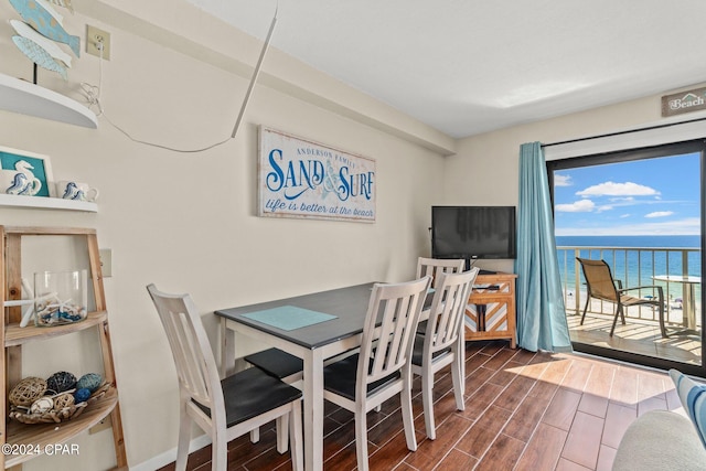 dining area with a water view and dark hardwood / wood-style floors