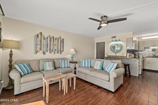 living room with dark wood-type flooring, ceiling fan, and sink