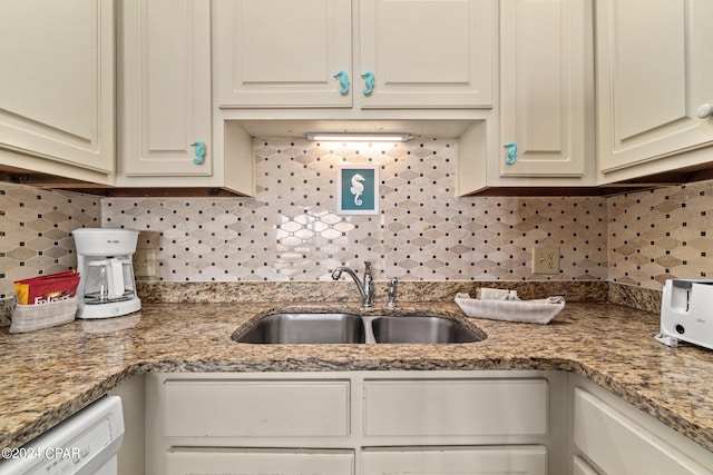 kitchen with white cabinets, white dishwasher, sink, and light stone counters